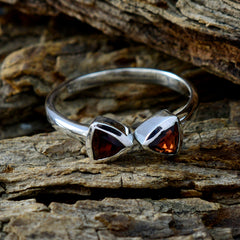 Seo-yeon red toi et moi ring with two red triangular gemstones set in a silver band on wood