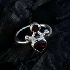 Savannah red toi et moi ring with two red gemstones set in polished silver band on dark background