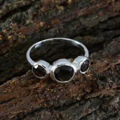 Ayaka romantic brown gemstone ring with three polished brown stones set in silver band on bark background
