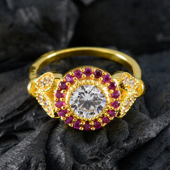 Jia romantic red halo ring with gold band, central clear stone, and surrounding red gemstones