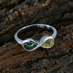 Li Lee silver Toi et Moi gemstone ring with green and yellow stones on textured wood