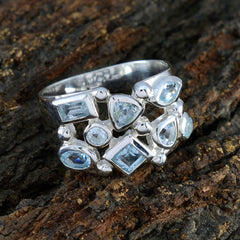 Nisa trendy blue gemstone ring with multiple blue stones set in silver band on textured wood