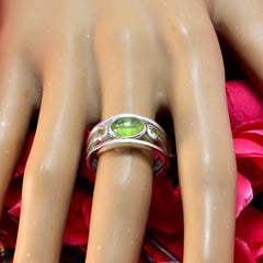 Putri trendy green gemstone ring with oval green stones set in silver band on display hand