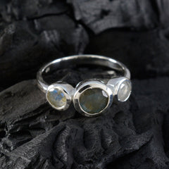 Nisa trendy grey gemstone ring with three oval stones set in silver on textured black background