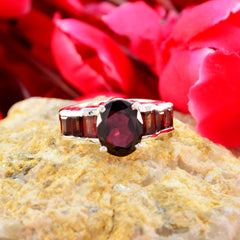 Andrea trendy red gemstone ring with oval center stone and rectangular side stones on rock