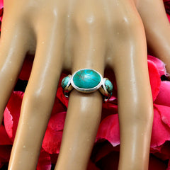Turquoise gemstone ring by Fernanda with three oval stones set in silver on a mannequin hand