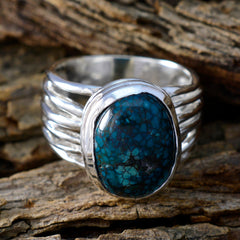 Emilia turquoise solitaire ring with a large blue stone set in a silver band on wood background