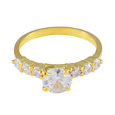 Dewi white gemstone gold ring with a large center stone and smaller side stones in gold band