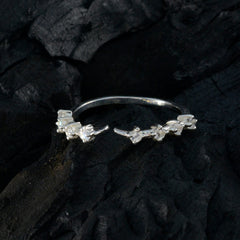 Riya white gemstone ring for women with delicate silver setting on a dark textured background