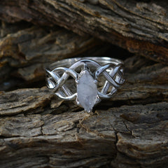 Charlotte white solitaire art deco ring with intricate silver band on rustic wood background