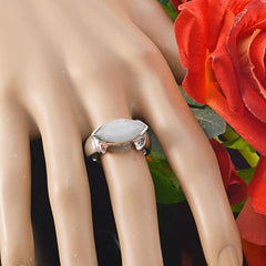 Bruna white solitaire filigree ring with marquise-shaped stone worn on a mannequin hand next to red roses