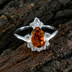 Lakshmi yellow gemstone halo ring with pear-shaped orange stone and surrounding clear gems on silver band