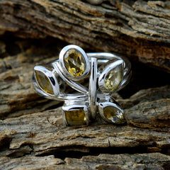 Priya silver yellow gemstone penta ring with five mixed cut yellow stones set in a floral cluster on rustic wood background