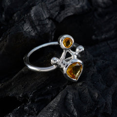 Rosa yellow gemstone toi et moi ring with two yellow stones set in silver band on dark textured surface