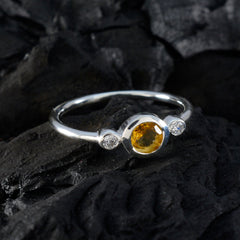 Dewi yellow gemstone trilogy ring with a central yellow stone and two smaller clear stones on a silver band