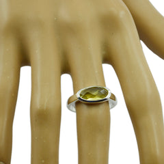 Sakura yellow solitaire ring with oval faceted yellow gemstone in silver bezel setting on mannequin hand