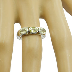 Putri yellow trilogy ring with three oval yellow gemstones set in silver band on a display hand