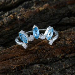 Josephine blue crown trilogy ring with three marquise blue stones and silver band on textured wood