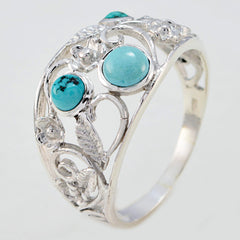 Meera turquoise trilogy ring with three turquoise stones set in an intricate silver floral design