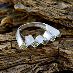 Ayesha silver green gemstone statement ring featuring multiple small green gemstones set on textured wood background
