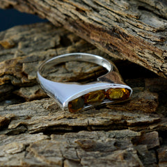 Eliza modern yellow gemstone ring with three yellow stones set in silver band on rustic wood