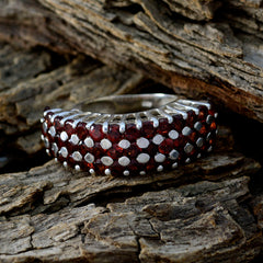 Julia Victorian red gemstone ring with multiple red stones set in silver band on rustic wood