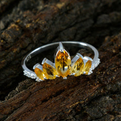 Araya yellow gemstone crown ring with marquise-cut stones set in silver band on rustic wood