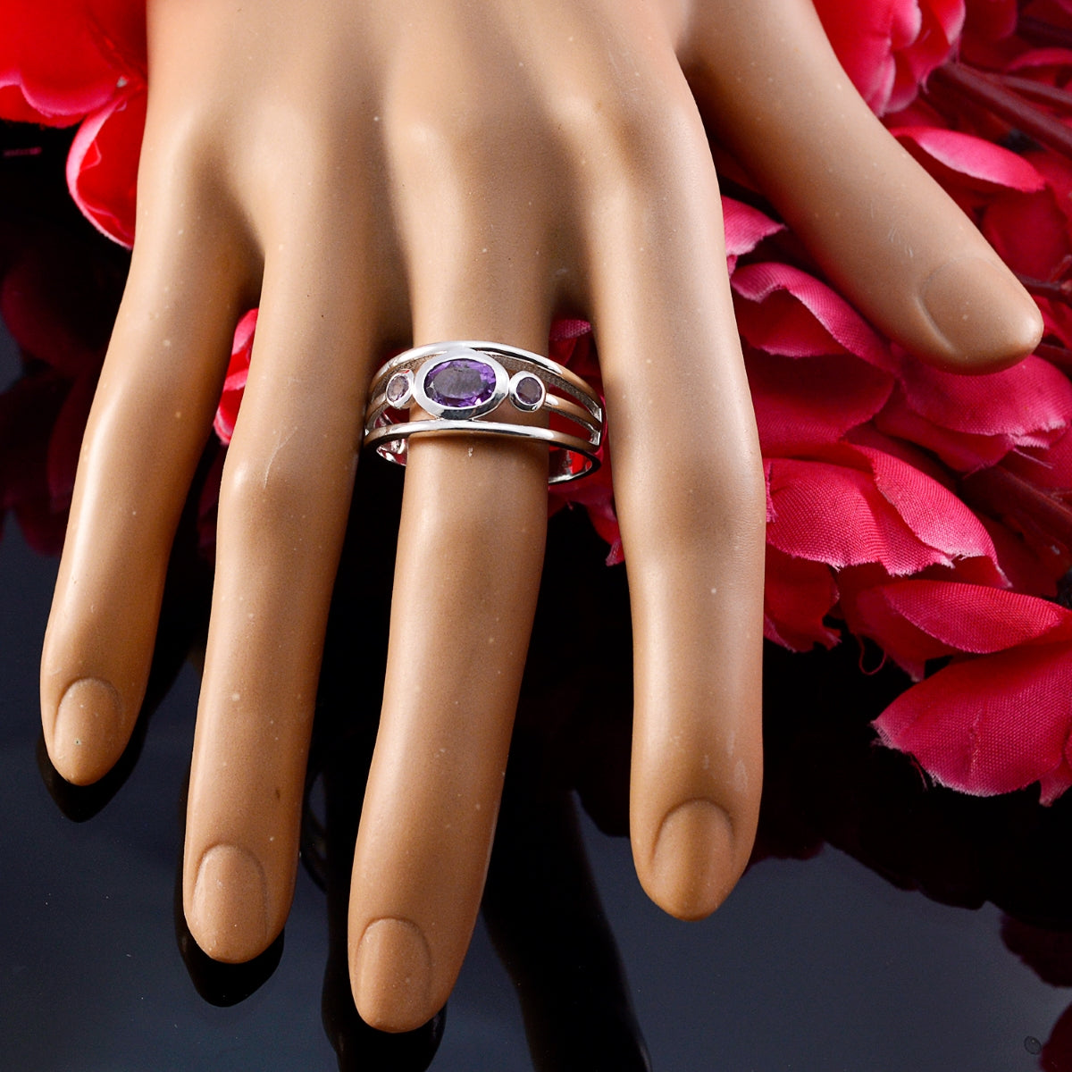 Tereza abstract purple gemstone ring on display hand with pink flowers background