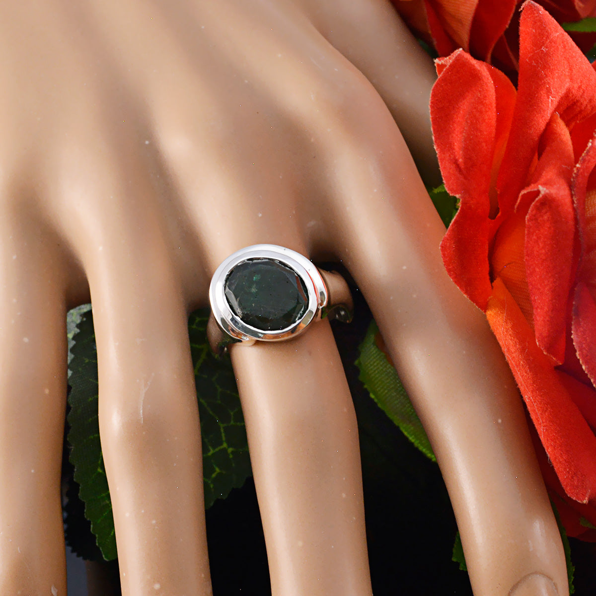 Savannah green solitaire ring with round deep green stone in polished silver bezel on hand