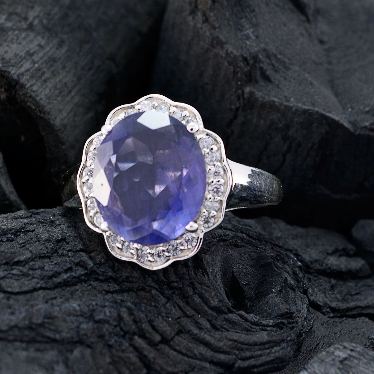 Laura blue halo ring for women with oval blue gemstone and diamond accents on silver band