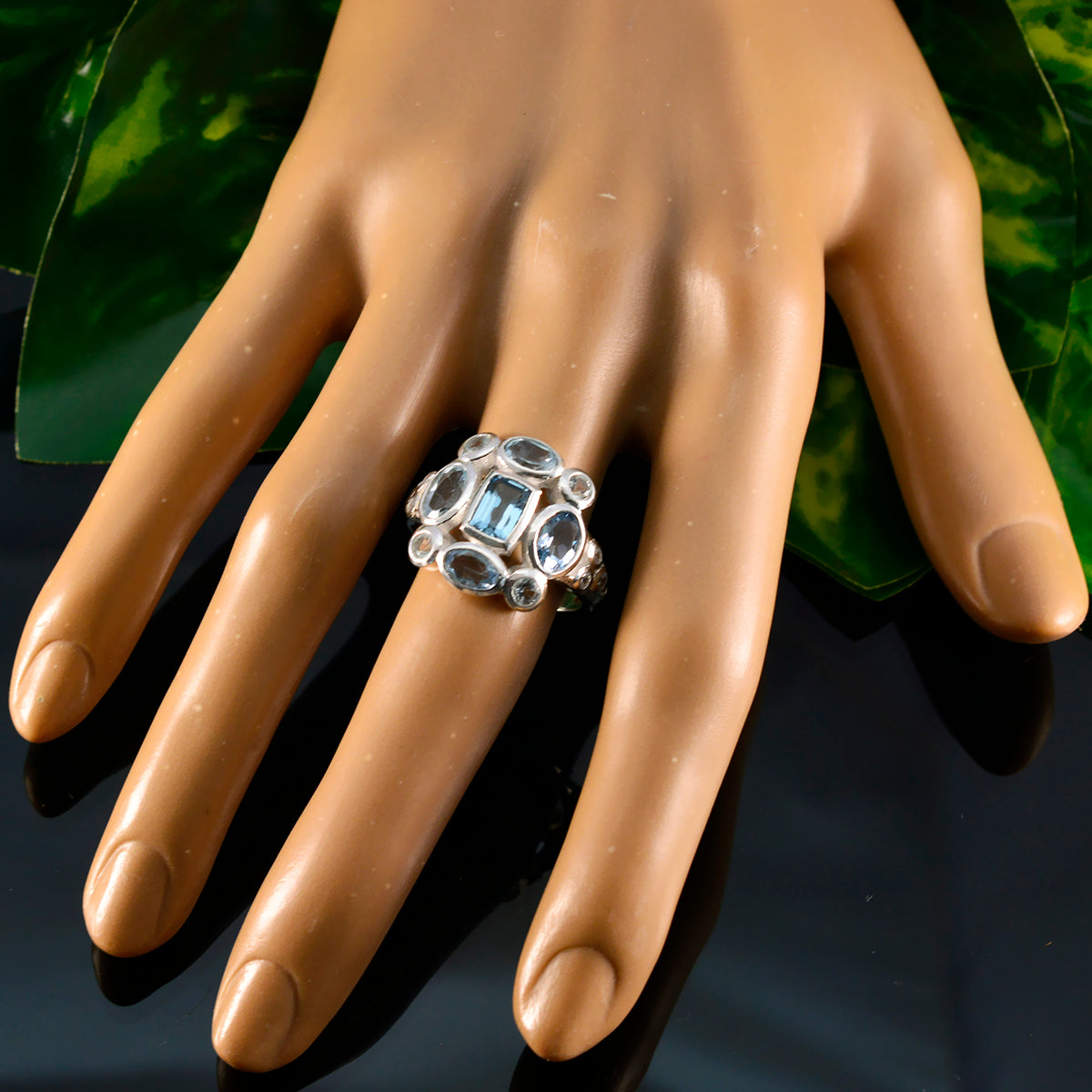 Dewi blue navratna gemstone ring with multiple stones on display hand model