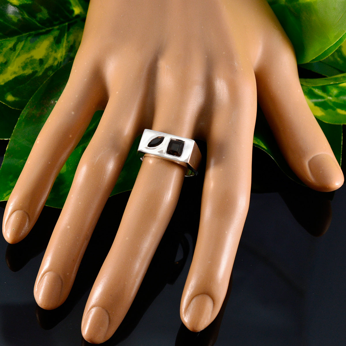 Victoria brown gemstone toi et moi ring with two stones worn on mannequin hand with green leaves background