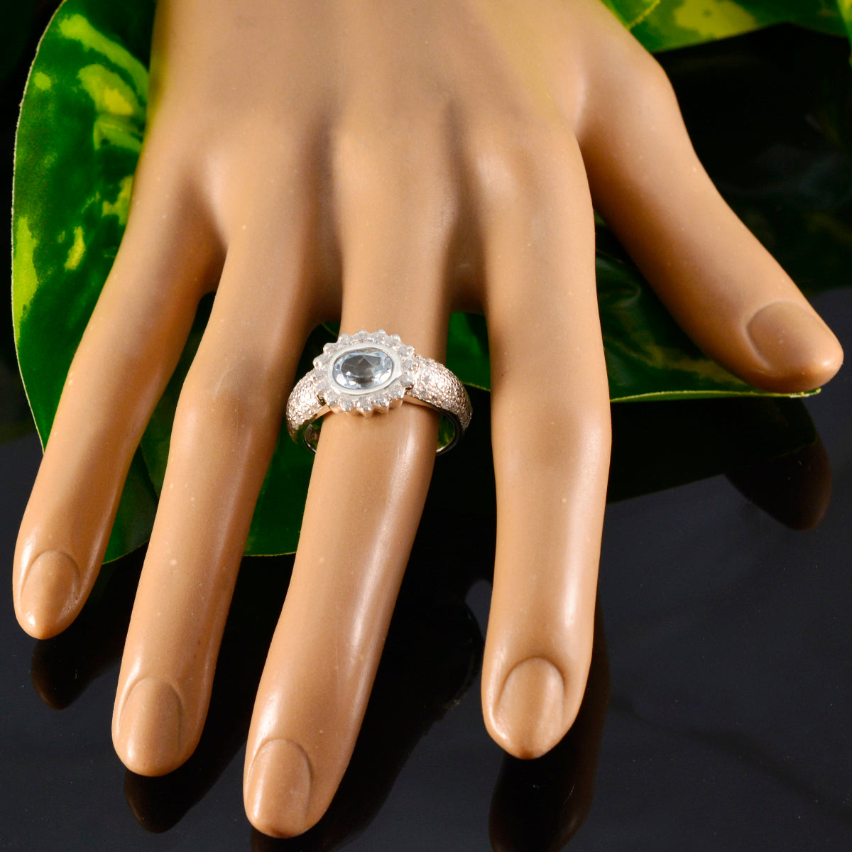 Putri artisan blue halo ring with light blue center stone and diamond halo on silver band displayed on hand