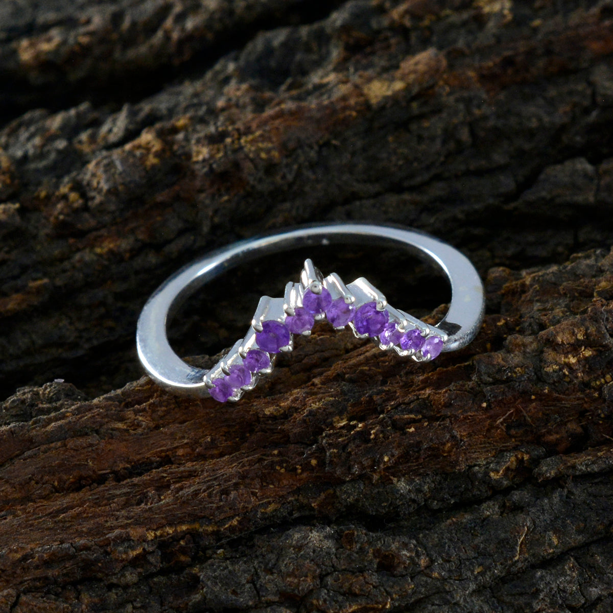 Jia sterling silver V shaped band with small amethyst stones purple gemstone crown ring on rustic bark