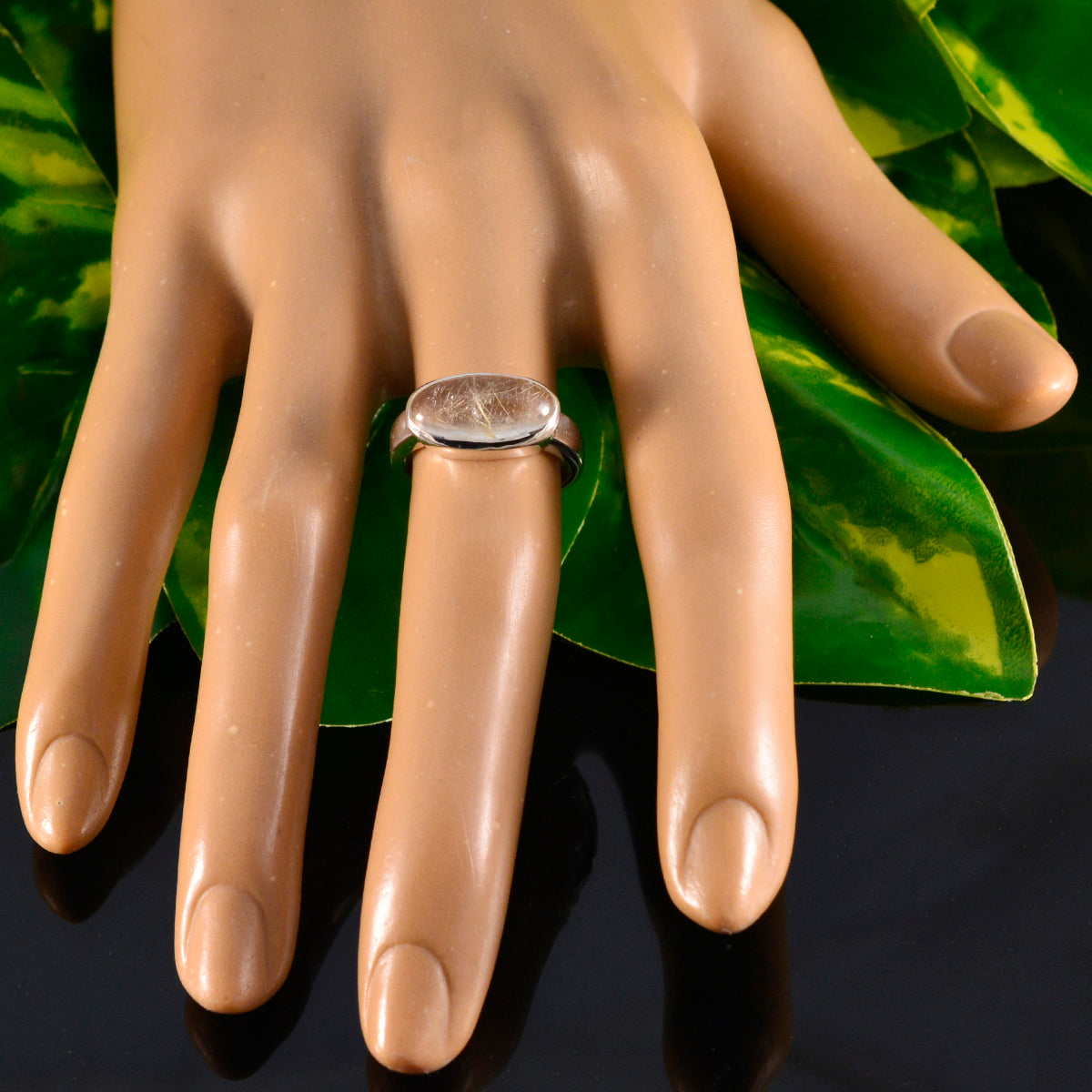 Claire modern solitaire ring for women with a smooth oval stone on silver band worn on mannequin hand