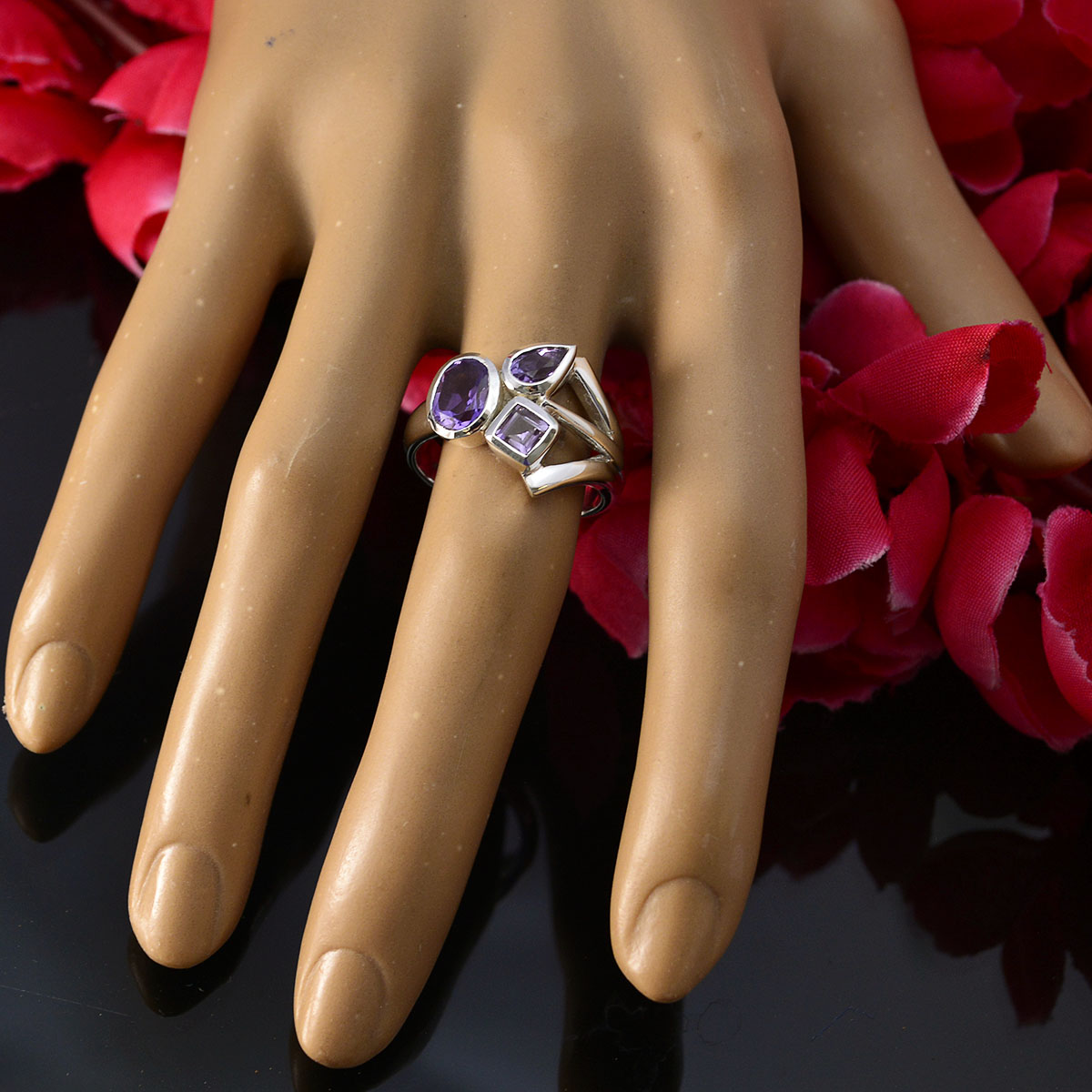 Saanvi purple gemstone trilogy ring with three distinct purple stones on a mannequin hand