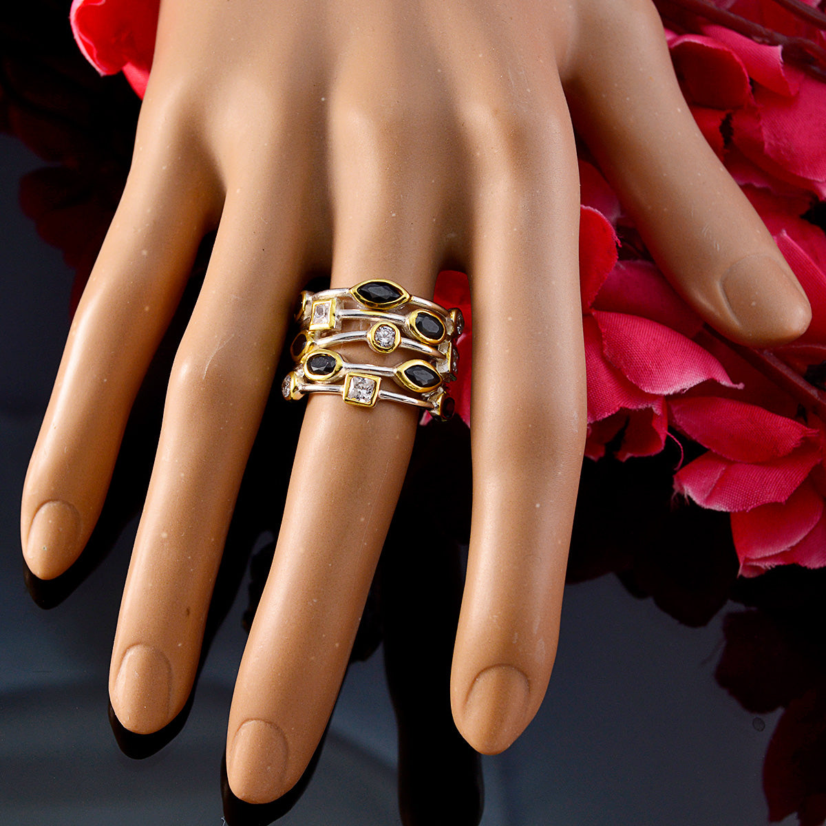 Isabella black gemstone statement ring with gold band featuring black and clear stones on mannequin hand