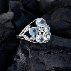 Julieta blue gemstone statement ring with multiple aquamarine stones set in silver on dark textured background