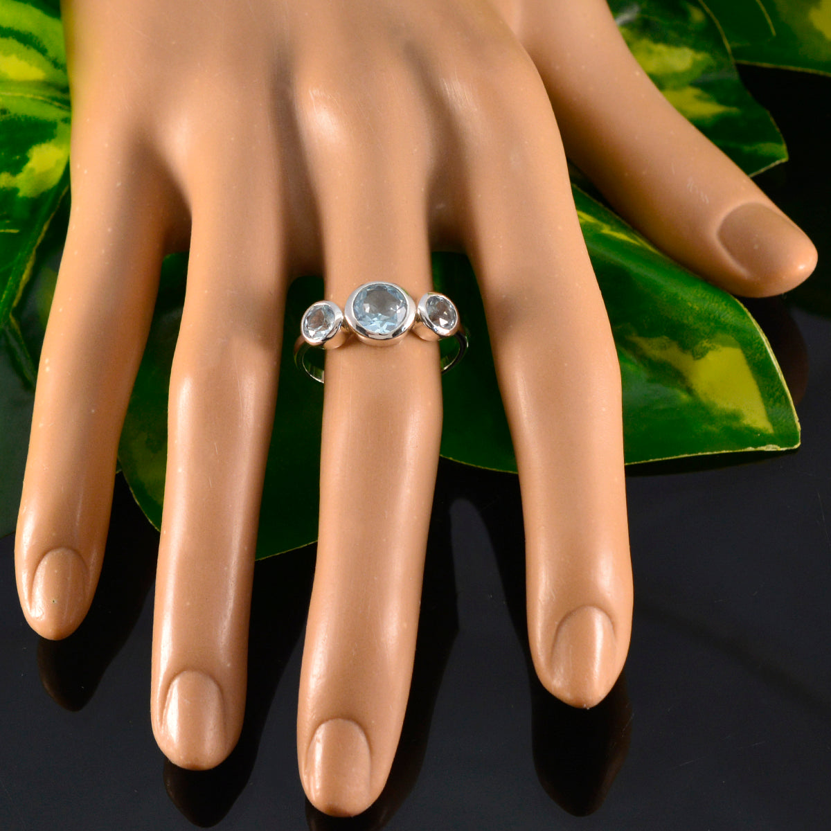 Natcha blue gemstone trilogy ring sterling silver with three round blue stones shown on mannequin hand