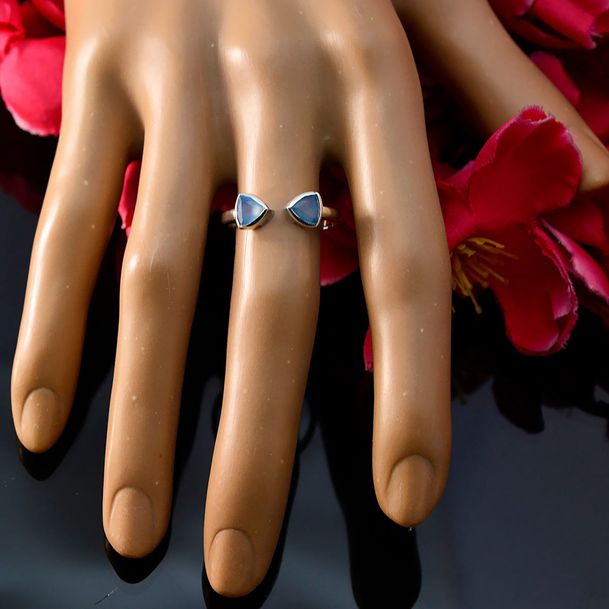 Sakura blue toi et moi ring with two triangular blue gemstones on silver open band displayed on hand