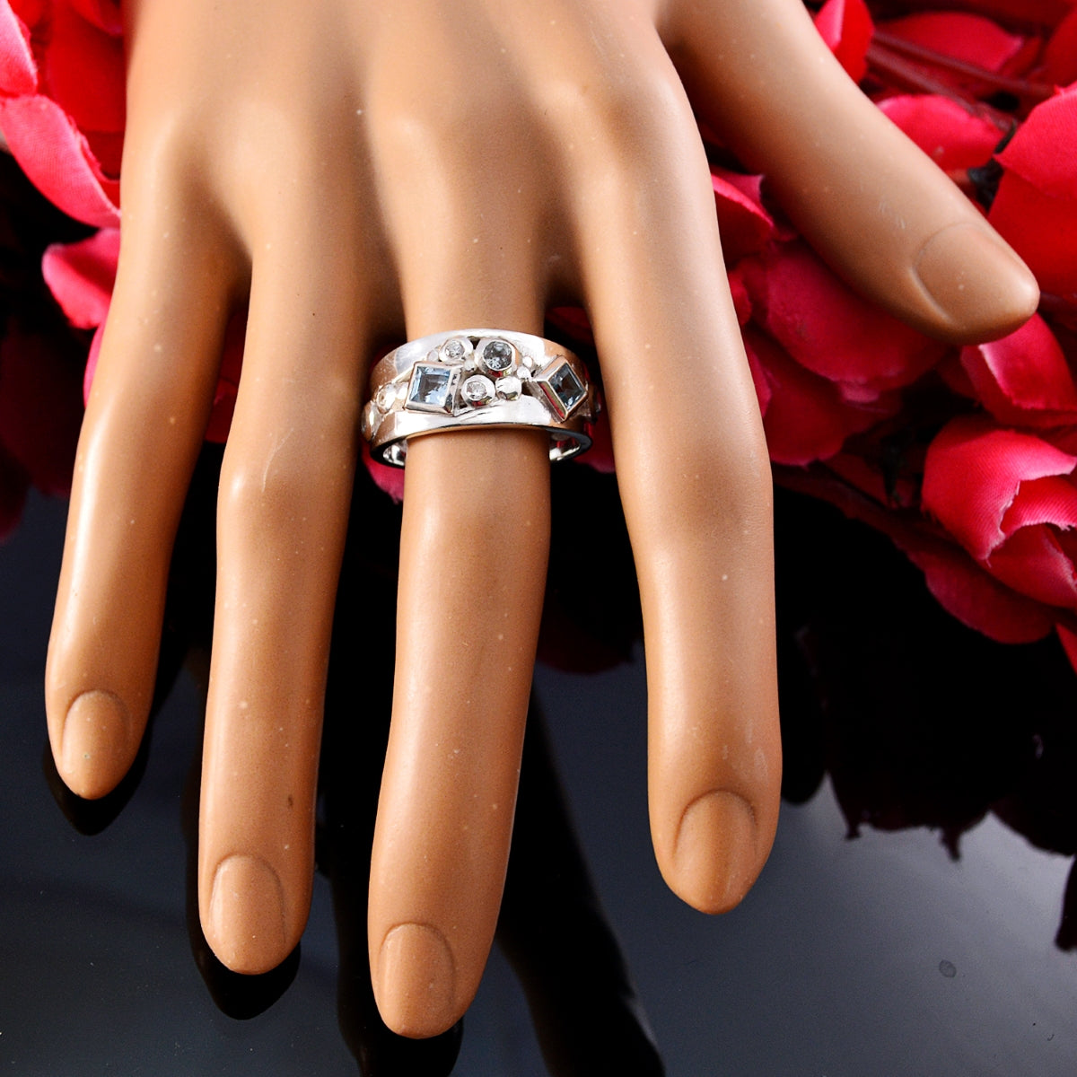 Angel contemporary blue trilogy ring silver band with three blue gemstones and accent diamonds on display hand