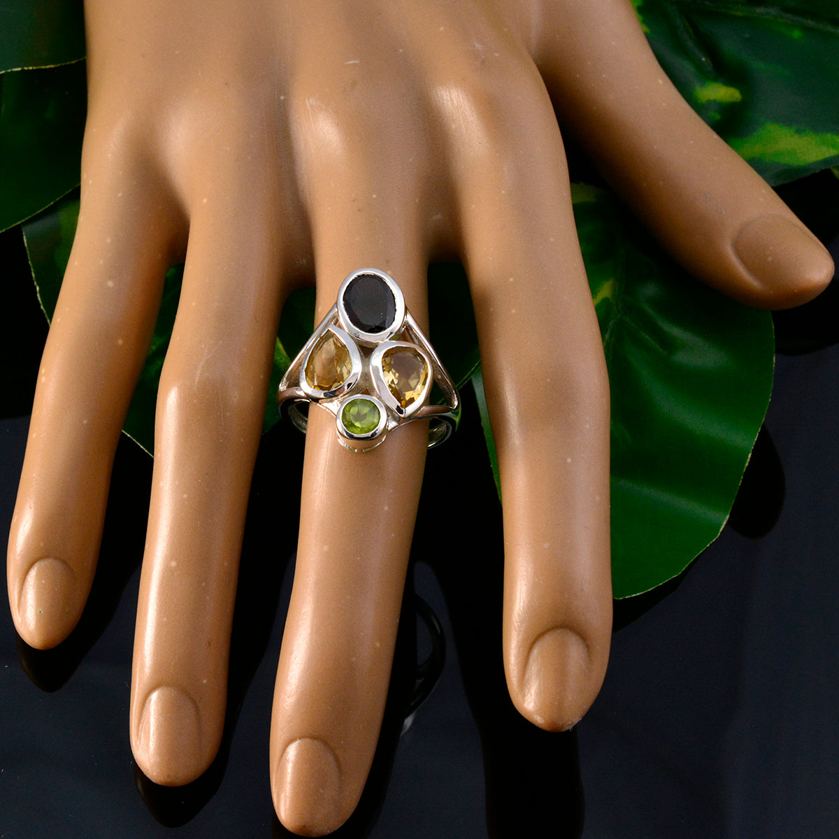 Isabella contemporary multicolor gemstone ring with black oval stone two citrine teardrops and green peridot on mannequin hand