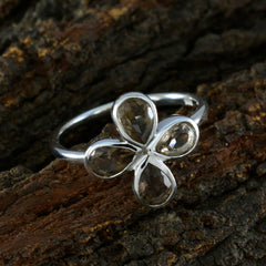 Hana floral brown gemstone ring with four petal-shaped stones set in silver band on textured wood