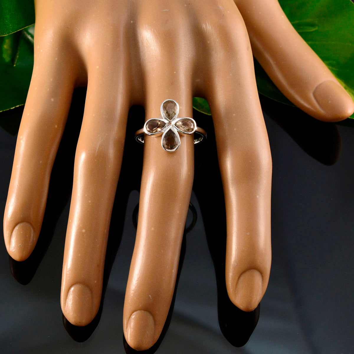 Hana floral brown gemstone ring with silver floral design on display hand model
