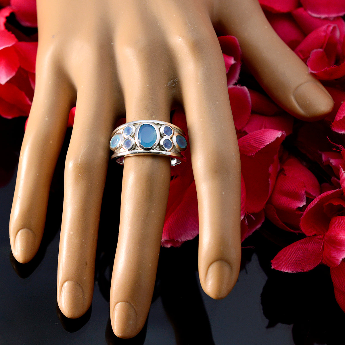Isabelle blue gemstone statement ring with oval and round blue stones on silver band displayed on hand