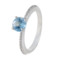 Maria blue halo ring with a round blue gemstone and a silver band encrusted with small diamonds
