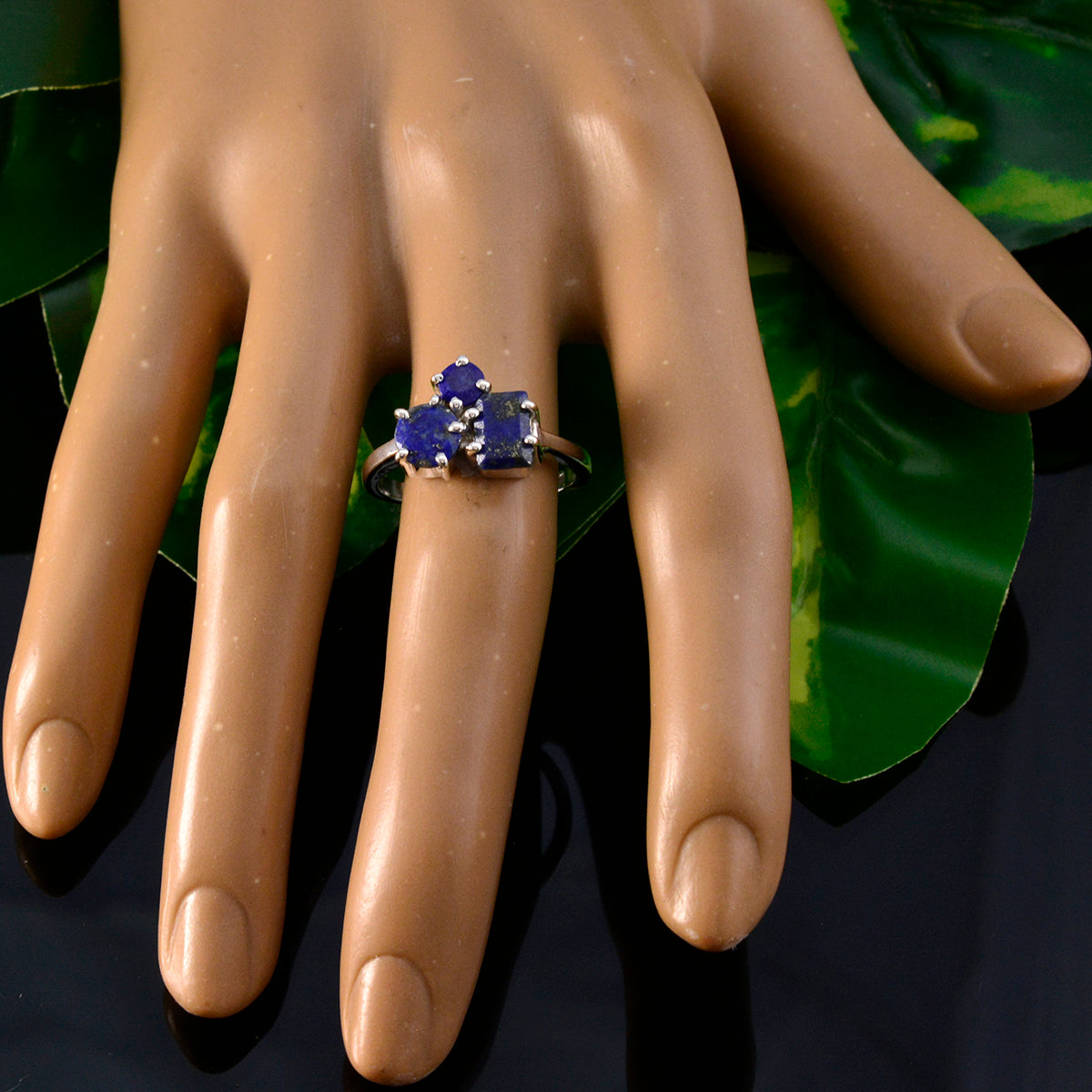 Noelia blue trilogy ring for women with three blue gemstones on silver band displayed on mannequin hand