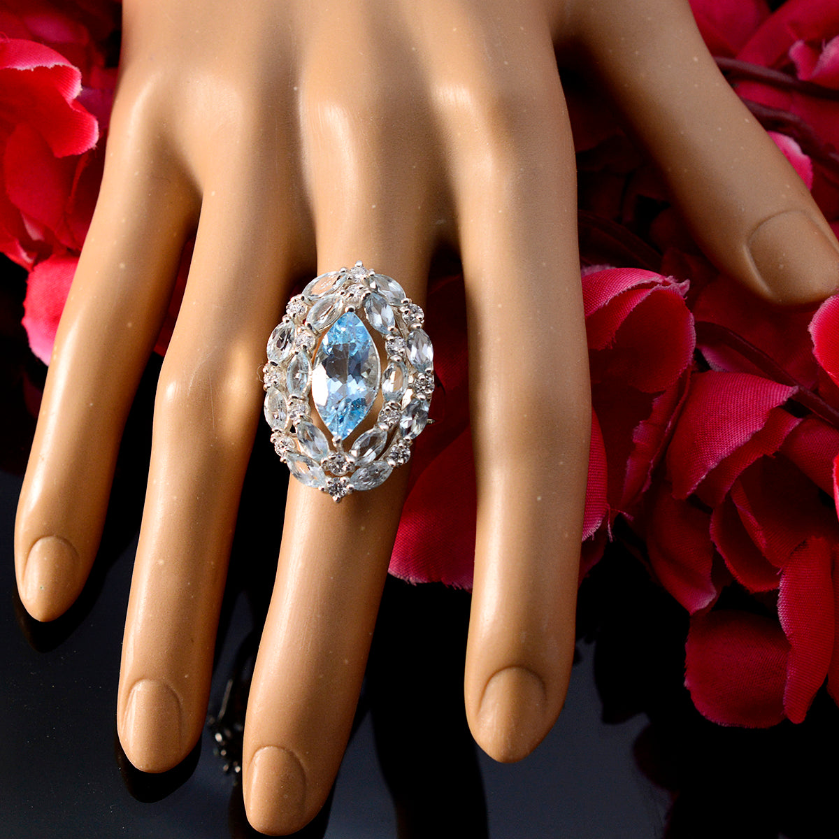 Tereza contemporary blue gemstone ring with marquise cut surrounded by clear stones on display hand