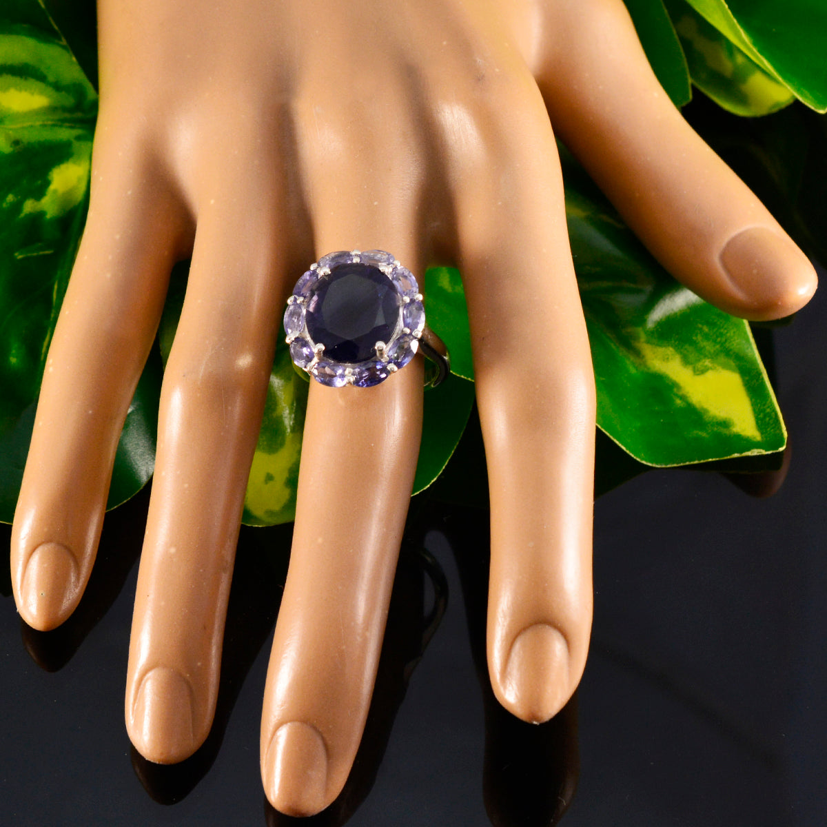 Lucia contemporary blue gemstone ring with a dark blue center stone surrounded by smaller gems on hand