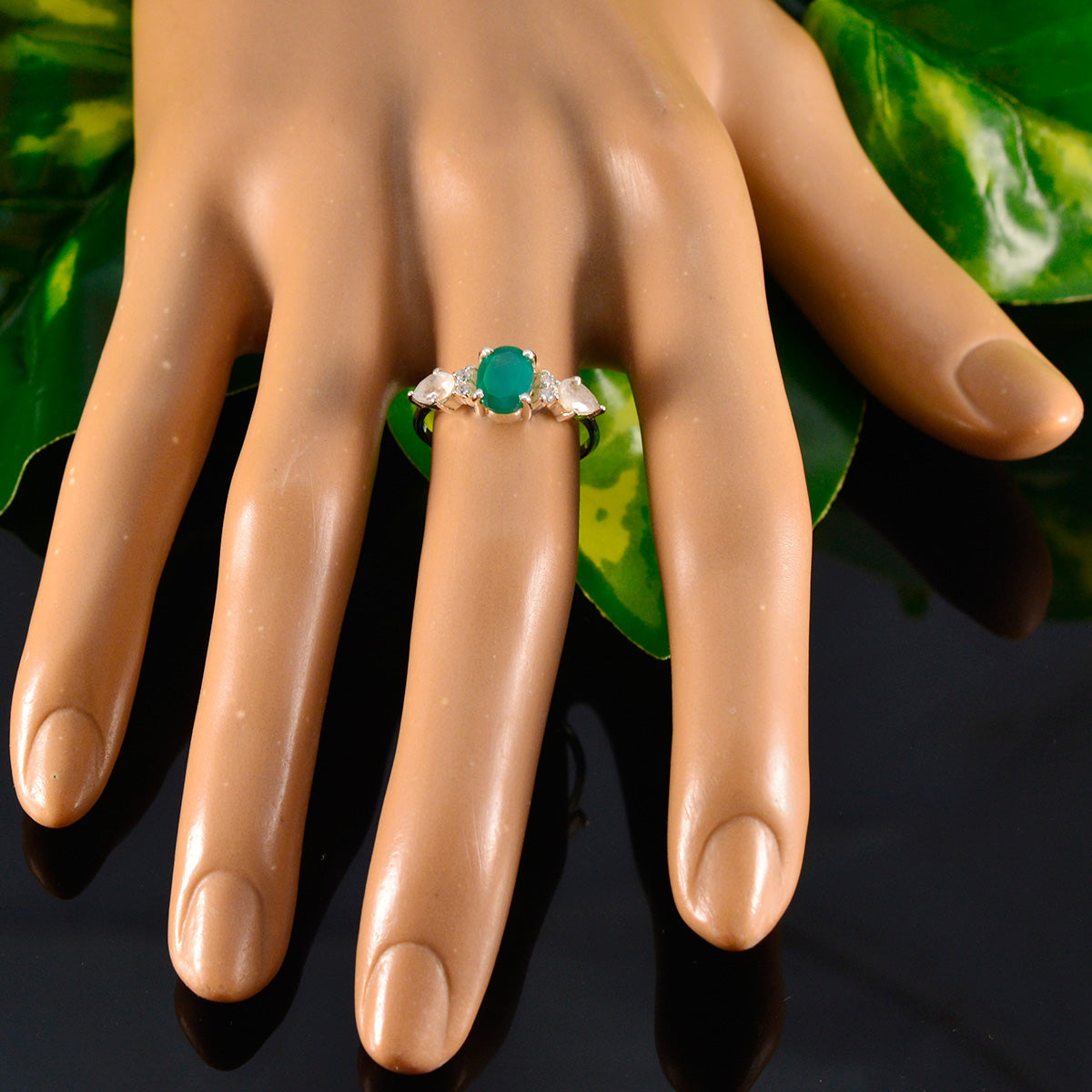 Laura multicolor trilogy ring for women with green center stone and clear side stones on display hand
